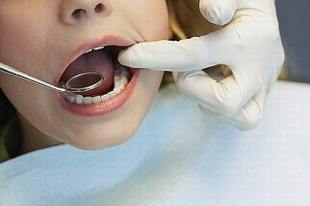 стоматолог проводит диагностику зубов